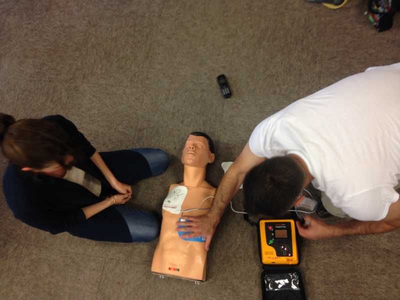 Loïc équipe un mannequin d'un défibrillateur