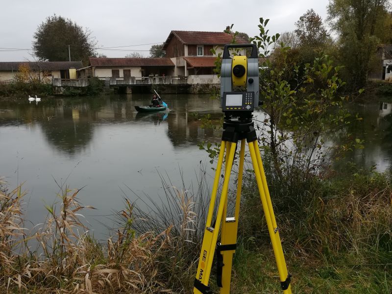 Baadïs navigue sur un étang avec le canoë pour prendre des points topo au tachéomètre.