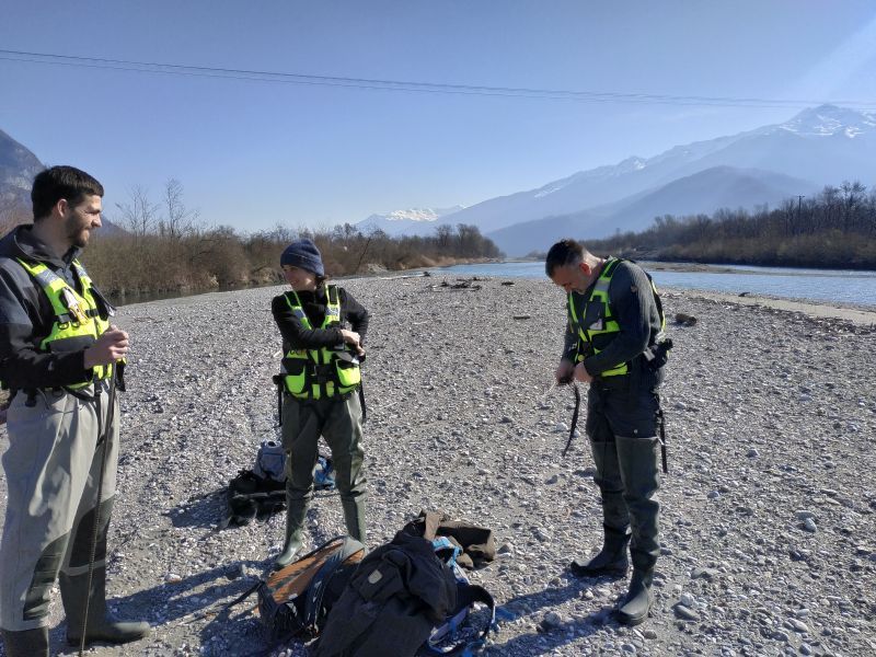 Photo d'une partie de l'équipe Dynamique Hydro (Alexia Chiavarino, Simon Chabbert, Loïc Grosprêtre) sur le terrain dans le lit de l'Isère. Conformément à notre protocole sécurité MASE, ils sont équipés notamment de gilets de sauvetage