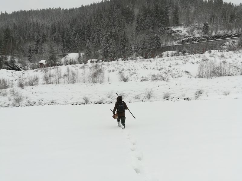 Loïc sous la neige portant une pelle pour creuser la neige à la recherche des parcelles peintes Loïc sous la neige portant une pelle pour creuser la neige à la recherche des parcelles peintes