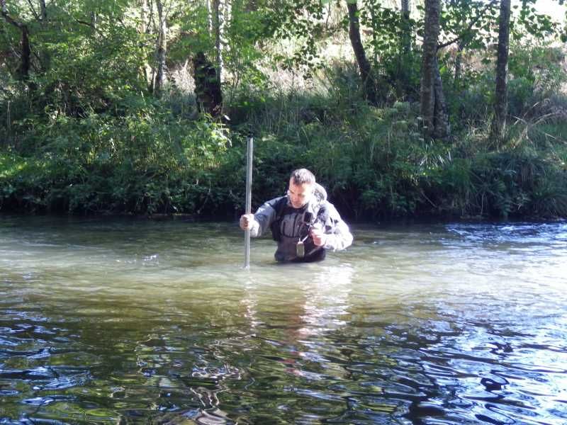 Loïc en waders réalise un relevé de hauteur d'eau