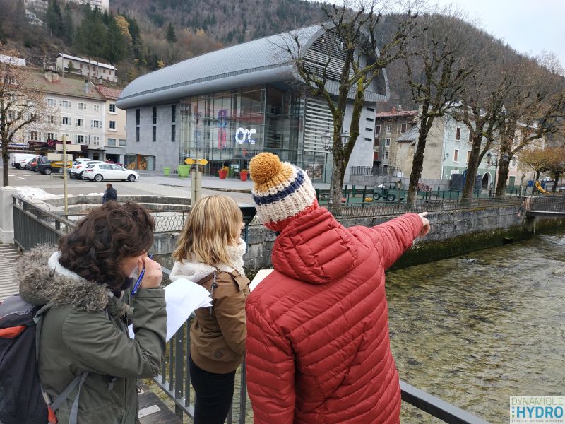 balade urbaine dans le cadre de la restauration écologique des berges de la Bienne dans le Jura. Photo d'une personne expliquant le fonctionnement hydraulique du cours d'eau